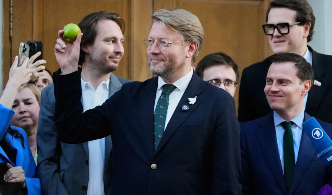 Det ryska oppositionspartiet Jablokos partiledare Nikolaj Rybakov håller i ett äpple, partiets symbol. Foto: Pavel Bednyakov/AP/TT