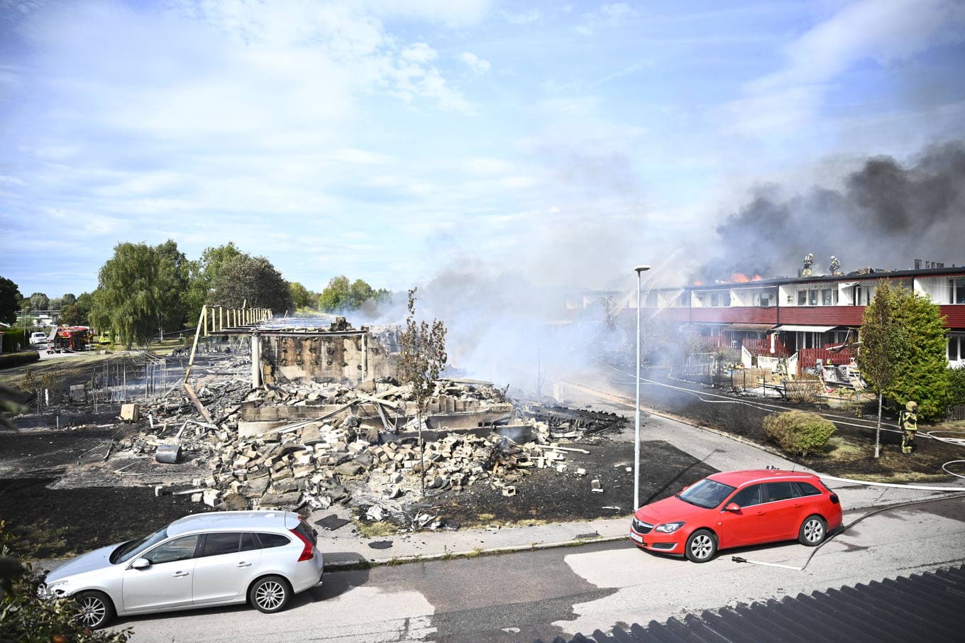 Släckningsarbete i radhuslängorna i Arboga på fredagen. Foto: Fredrik Sandberg/TT