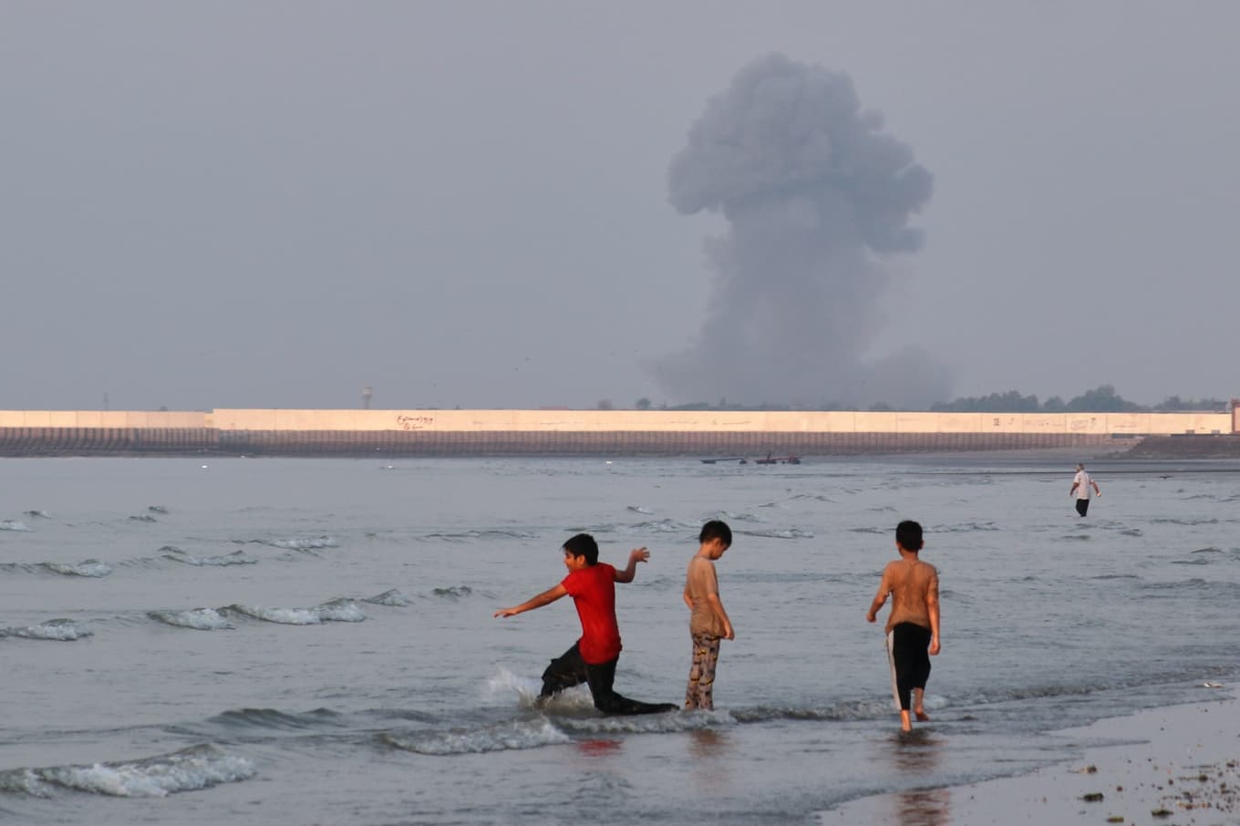 Hormuzsundet i mitten av juli medan rök stiger i bakgrunden från attacker mot iranska mål. Foto: Razieh Poudat/AP/TT