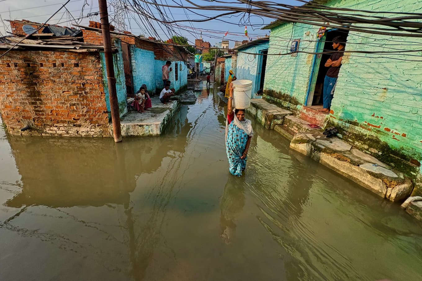 En kvinna vadar i ett översvämmat område i Kanpur i Uttar Pradesh i norra Indien. Bild från i förra veckan. Foto: AP/TT