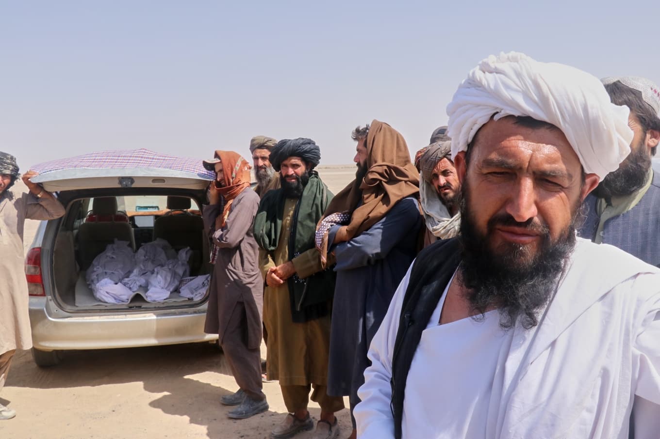 Afghanska män står vid ett fordon med kvarlevor av dödade personer i, i afghanska Helmand på torsdagen. Foto: Abdul Khaliq/AP/TT