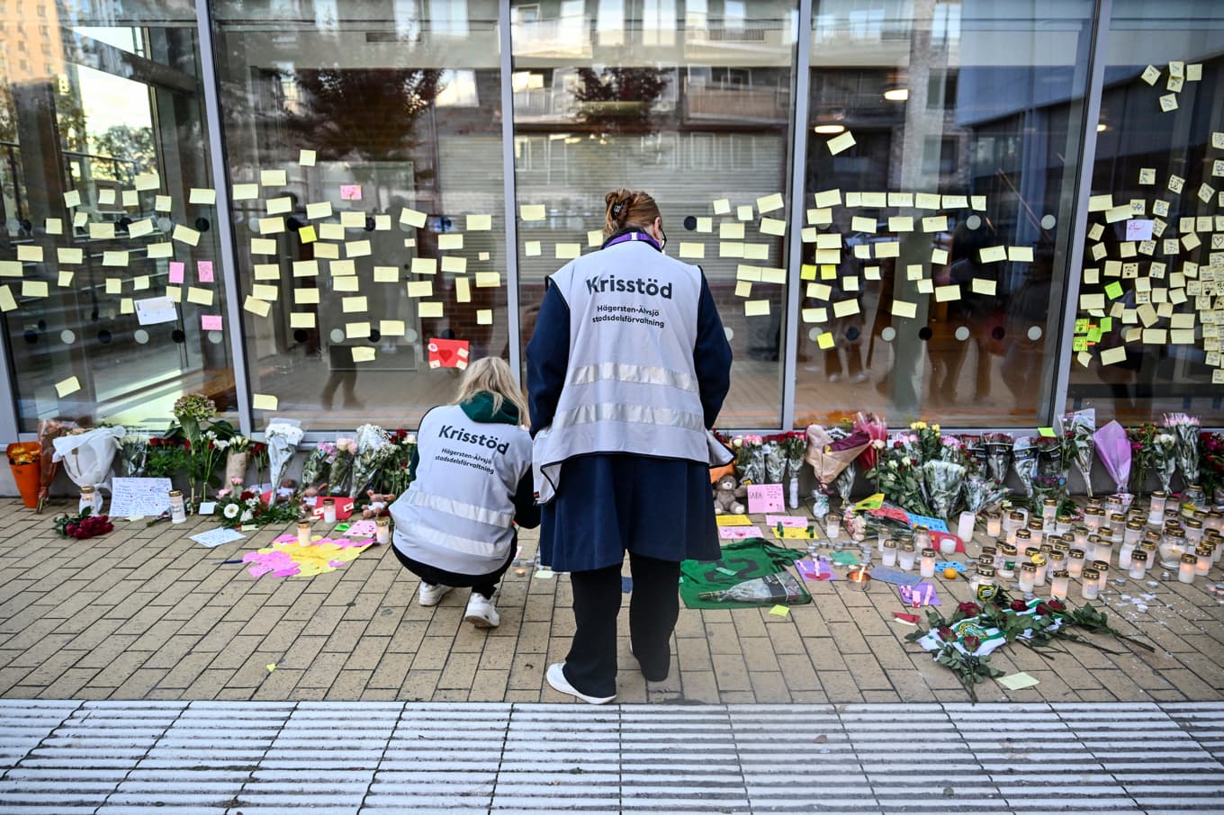 Sörjande har lämnat blommor och ljus utanför Kämpetorpshallen i Solberga, Älvsjö där en 24-årig kvinna blev skjuten på fredagskvällen och senare avled. Foto: Pontus Lundahl/TT