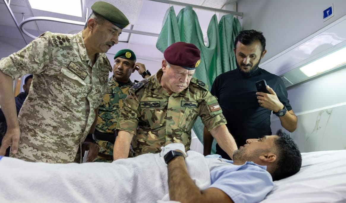 Kung Abdullah II, i röd basker, besöker en skadad man efter attacken mot en kyrka i södra delarna Jordanien. Foto: Det jordanska hovet/AP/TT