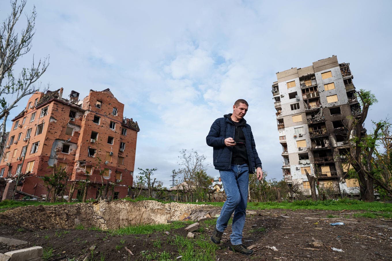 En man går förbi två förstörda bostadshus i Olesjky i södra Ukraina. Bild från i onsdags. Foto: Evgeniy Maloletka/AP/TT
