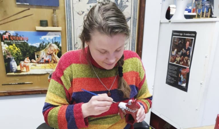 Med stadig hand målar Marie-Louise Lind dalahästen, ett motiv som knyter hennes eget skapande till Dalarna och familjens tradition. Foto: Privat