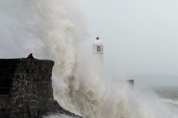 STORBRITANNIEN, Porthcawl: Vågor slår upp mot barriärer i Porthcawl, södra Wales den 27 Oktober 2013 inför ankomsten av en förutsedd storm. England var förberedd den 27 oktober för den värsta stormen på ett decennium, med kraftigt regn och vindar på mer än 130 kilometer i timmen. (Foto: Geoff Caddick/AFP)