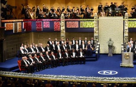 Nobelpristagarna har intagit sina stolar i Konserthuset som är dekorerat med tavlor med levande blommor. (Foto: Jonathan Nackstrand / AFP)
