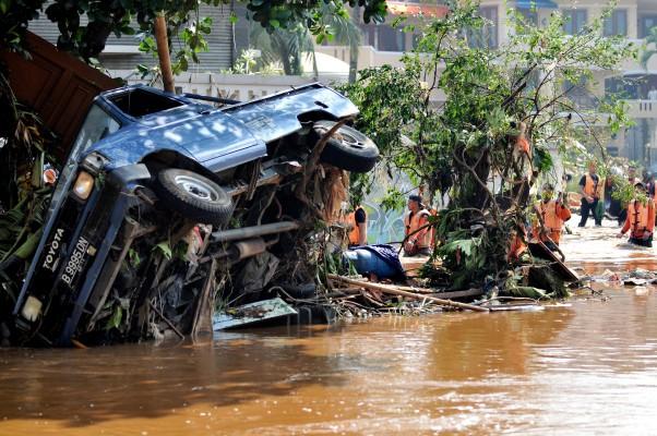 Räddningsteam letar efter överlevande under fordon och träd i Tangerang i Indonesien den 27 mars 2009. (Foto: Adek Berry/AFP 

