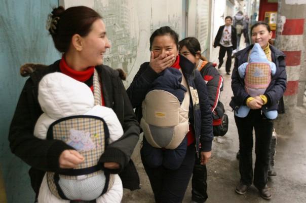 Tre kvinnor från Xinjiang med spädbarn, på besök i Shanghai. Kina har, utöver ettbarnspolitiken, fokuserat på att "korrigera en potentiellt destabiliserande könsbalans", då det föds fler pojkar än flickor.  (Foto: Mark Ralston/ AFP)