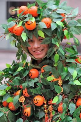 Mannen är dekorerad med glada mandariner inför en drakdans i Shanghai den 8 februari som ett led i nyårsfirandet. Glad blir magen om du torkar mandarinskal och sedan använder dem att göra te på, när du har magsmältningsproblem. (Foto: Philippe Lopez / AFP)