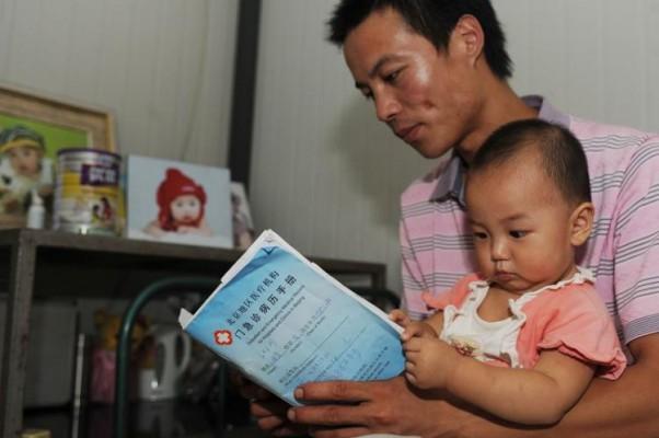Pekingbon Wangs 13 månader gamla dotter utvecklade för tidiga pubertetssymptom efter att ha matats med mjölk från mjölkpulver tillverkat av företaget Synutra International. Familjen Wang är en av många familjer som drabbats i mjölkskandalen. (Foto: Getty Images)