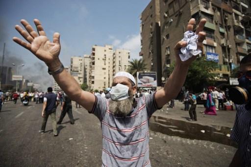 En av Egyptens avsatte president Mohamed Morsis supportrar gestikulerar vid pågående sammandrabbningar med kravallpolisen på torget  Rabaa al-Adawiya i Kairo den 14 augusti 2013. (Foto: Gianluigi Guercia/ AFP) 