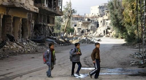 Syriska barn korsar en gata för att gå till skolan, så man försöker upprätthålla ett vanligt liv.Det här är staden Deir Ezzor den 23 january  (Foto: Ahmad Aboud / AFP) 