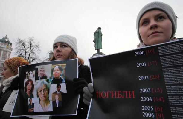 Demonstranter i Moskva håller upp bilder på dödade kända ryska journalister, i december 2010. (Foto: AFP/Alexey Sazonov)
