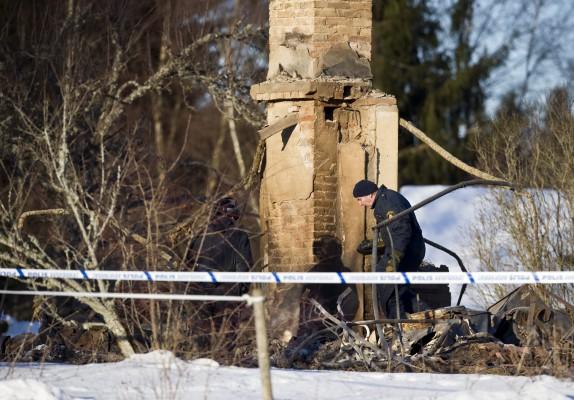 Polisen undersöker huset efter branden där Per Oscarsson och hans fru hade bott i tio år. (Foto: AFP/ Björn Larsson Rosvall)
