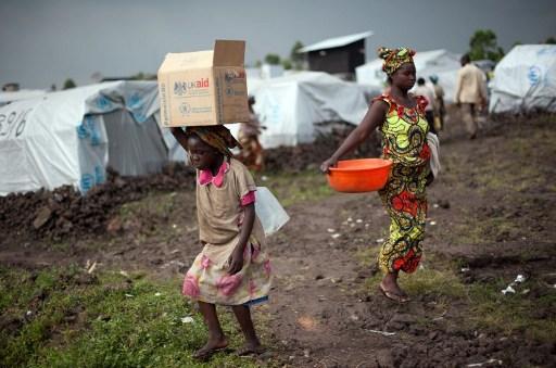 En kongolesisk flicka bär på en låda med livsmedel i Mugunga III, ett läger för internflyktingar i östra delen av Kongo den 2 december 2012. (Foto: Phil Moore/AFP)