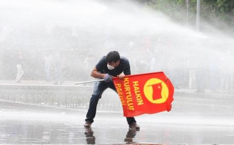 Mannen försöker skydda sig från vattenkanonen under sammandrabbningar med polis vid en regeringskritisk demonstration den 16 juni i Ankara. Premiärminister Erdogan försvarade polisens våldsamma tillslag mot demonstranterna och sade att det var hans ”plikt” att beordra evakueringen av parken. (Foto: Adem Altan / AFP)
