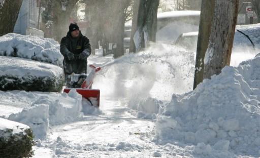 En man skottar en trottoar med hjälp av en snöslunga i Bronx, New York den 3 januari 2014. En våldsam vinterstorm och mer än 61 cm snö gjorde att undantagstillstånd förklarades i helgen i New York och New Jersey. (Foto: Don Emmert/ AFP)
