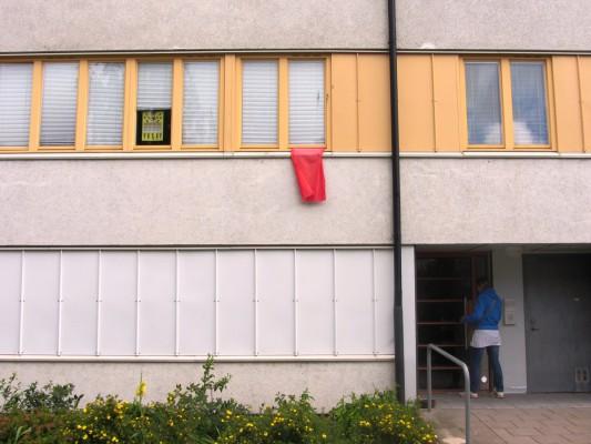 Flera hyresgäster har hängt ut något rött genom fönstret som en symbol för deras missnöje. (Foto: Susanne Willgren/Epoch Times Sverige)
