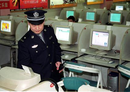 Kinesisk polisman inspekterar ett Internetcafé i Peking. (Foto: AFP)