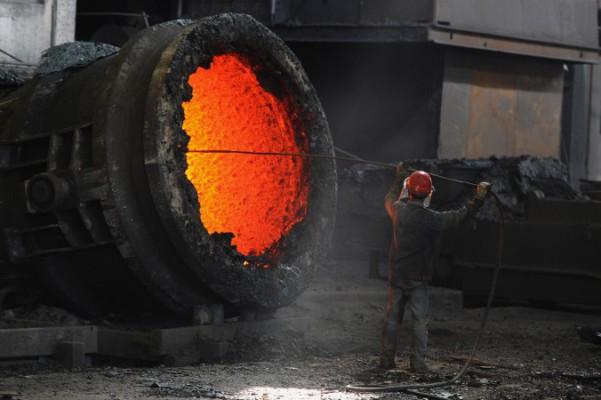 En kinesisk arbetare eldar i en kittel vid ett stålverk i Hefei i Anhuiprovinsen i östra Kina den 25 juni 2011. Kina har en betydande överkapacitet inom sin stålindustri och inom flera andra industrier. (Foto: STR/AFP/Getty Images)