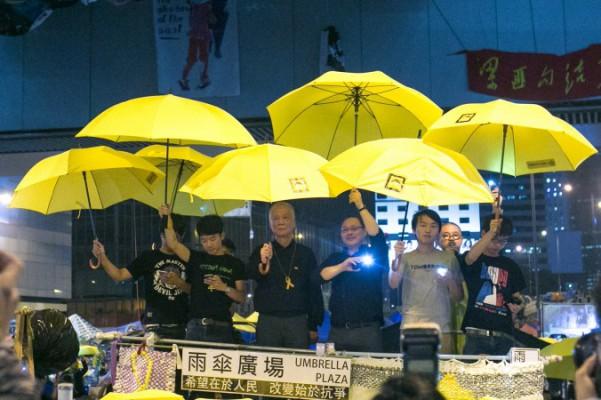 Några av de huvudsakliga studentledarna vid protesterna i Hongkong håller upp gula paraplyer för att markera att det gått en månad sedan protesterna i centrala Hongkong inleddes, 28 oktober 2014. (Foto: Benjamin Chasteen/Epoch Times) 