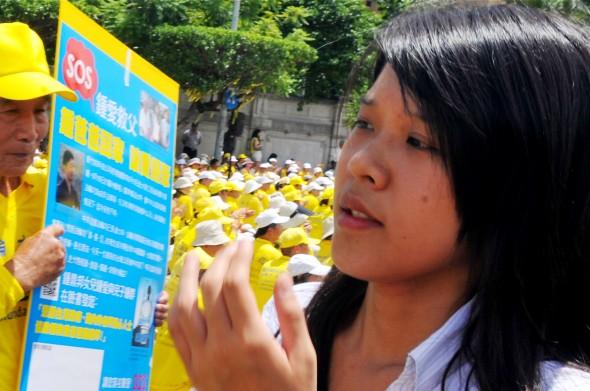 Chung Ai, dottern till den taiwanesiske mannen Chung Ting-Pang som greps i Kina i juni, vid en sittprotest med hundratals Falun Gong-utövare i Taipei den 23 juli. (Foto: Mandy Cheng/AFP/Getty Images)