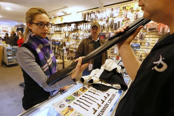 Naomi (efternamn undanhålls) inspekterar ett hagelgevär att köpa för att ha som skydd i hemmet, på "Get Some Guns &amp; Ammo "-skjutbanan den 15 januari 2013 i Salt Lake City, Utah. (Foto: George Frey / Getty Images)