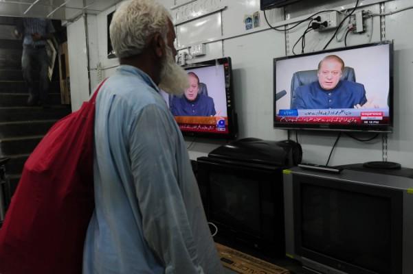 En pakistansk man ser på tv i en butik i Karachi, den 19 augusti 2013. Landets tillsynsmyndighet för media har utfärdat böter på tio miljoner rupier (cirka 1,2 miljoner kronor) till tio privata tv-kanaler som visat för mycket indiskt innehåll. (Foto: Asif Hassan / AFP / Getty Images)