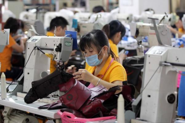 Arbetare i en skofabrik i Jinjiang i Fujianprovinsen i södra Kina, 17 september 2013. Ett stort antal tillverkningsföretag har gått i konkurs eller lagts ner i Kina på senare tid. (STR/AFP/Getty Images)
