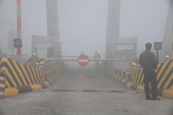 Ett stängt tullbås i smog i Jilinprovinsen, nordöstra Kina, 22 oktober i år. Skolor och lokala flygplatser har fått stänga på grund av smogen de senaste veckorna, och i vissa fall även motorvägar. (Foto: STR/AFP/Getty Images)