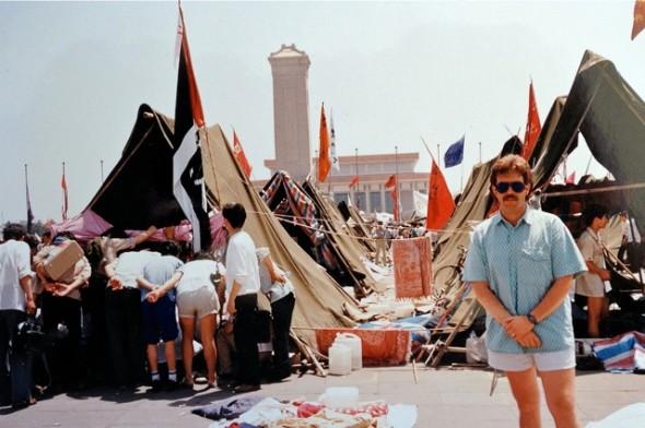 John Shackman står på Himmelska fridens torg den 3 juni 1989. I bakgrunden syns tälten som studenterna satt upp. Några timmar senare flydde han och hans fru från torget i panik när den kinesiska militären rullade in. (Med tillstånd av John Shackman)
