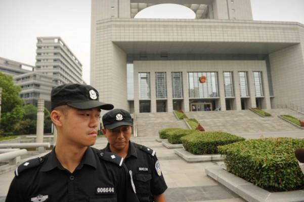 Poliser bevakar Hefeis mellanliggande folkdomstol i Anhuiprovinsen i Kina, 20 augusti 2012. De senaste dygnen har Kinas regim agerat mot de allt högljuddare människorättsförsvararna i landet med en massiv arresteringskampanj. (PETER PARKS/AFP/GettyImages)
