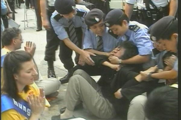 610-byrån styr förföljelsen både i och utanför Kina. Vid en stillsam Falun Gong-protest i Hongkong 2002 mot Jiang Zemins order om att "Döda utan pardon" pressades den lokala polisen att gripa 16 personer. (Foto: Clearwisom)