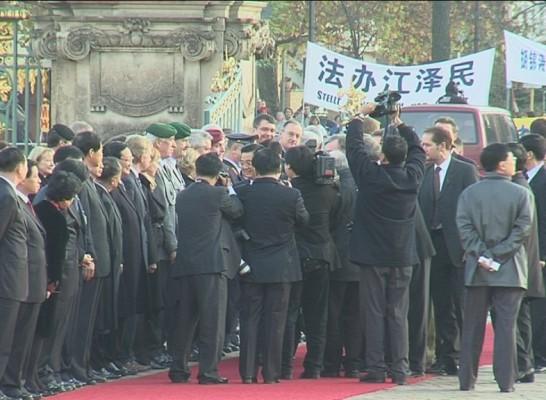 Hu Jintao på Charlottenburgs slott, omgiven av media. På banderollen i bakgrunden står det "Ställ Jiang Zemin inför rätta". Jiang Zemin är den förre ledaren för kommunistpartiet, ansvarig för att ha startat förföljelsen av Falun Gong. (Epoch Times)