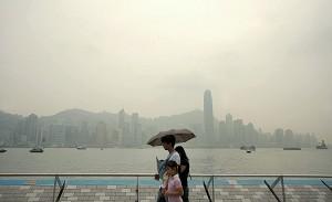Turister går i smoggen vid Victoria Harbour i Hongkong. En minskning av de atmosfäriska föroreningarna över Asien kan minska antalet tropiska regnfall i Australien visar en ny studie. (Foto: Samantha Sin/AFP/Getty Images)