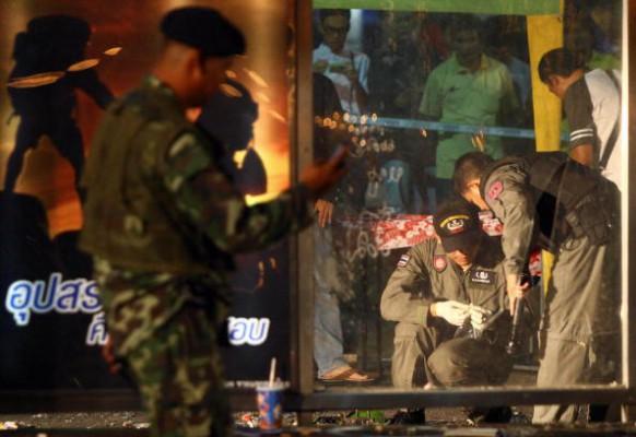 BANGKOK: Personal från en thailändsk bombgruppsenhet inspekterar förstörelsen vid en busshållplats nära Victory Monumentet i Bangkok. Förstörelsen orsakades av en bombexplosion strax innan nyårsfirandet den 31 december. (STR/AFP/Getty Images)
