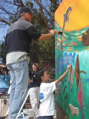 Scenerna från havet, fyllda med olika färger och djur, fyller snart väggmålningen då barnen målar tillsammans med Wyland. (Joshua Philipp/The Epoch Times) 
