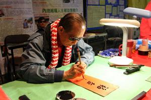 En ledare för mänskliga rättigheter i Hongkong, Szeto Wah, skriver verspar för att hylla det kinesiska nyåret, tillägnat invånarna i Hongkong under det kinesiska nyårsfirandet i Victoria-parken. Tillsammans med sju andra var Szeto delaktig i en utredning om den kinesiska kommunistregimens spioneri. (Foto: Wu Lianyou/Epoch Times)
