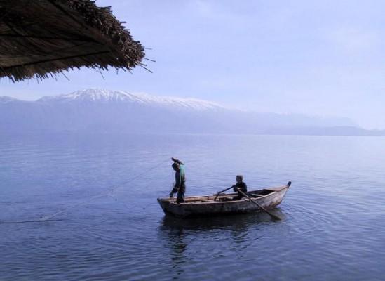 Albanska pojkar samlar ihop sina nät ute på sjön Ohrid. Sjön är bland de djupaste i världen. Liksom många av landets kulturarv och naturliga fenomen är den albanska musiken fortfarande relativt okänd för omvärlden. (Gent Shkullaku/AFP/Getty Images)