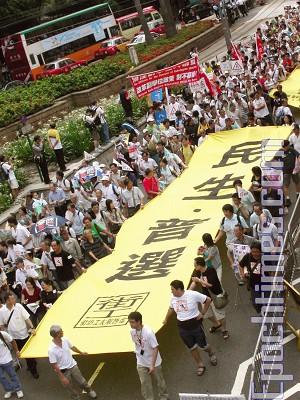 Grupper för mänskliga rättigheter och medborgargrupper marscherar i Hongkong och kräver demokratiska allmänna val och förbättring av levnadsstandarden. (Foto: Xu Poheng/The Epoch Times)