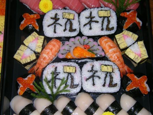 Ett  smakprov av Ken Kawasumis dekorativa sushi. De japanska tecknen är i-iwa-u eller shuku och betyder fira eller gratulera. (Med tillstånd från japanska föreningen)
