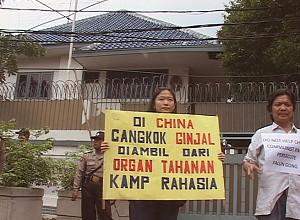 En Falun Gong-utövare håller upp en skylt framför den kinesiska ambassaden i Bangkok, Thailand den 20 februari. (NTDTV)
