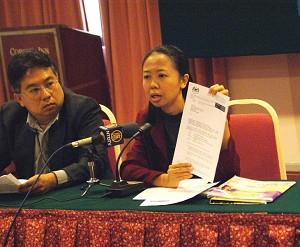 Huang Meiyi, talesperson för NTDTV, visar upp tillståndet och avbokningsmeddelandet från Malaysias regering på presskonferensen. (Foto: The Epoch Times)
