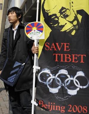 En medlem i en pro-Tibetgrupp håller i en banderoll med en bild på Tibets andlige ledare Dalai Lama, i Nagano den 25 april 2008. "KKP gick med på samtal med Dalai Lama endast för att lugna det växande trycket på att bojkotta Peking-OS". (Foto: Kazhuiro Nogi/AFP/Getty Images)