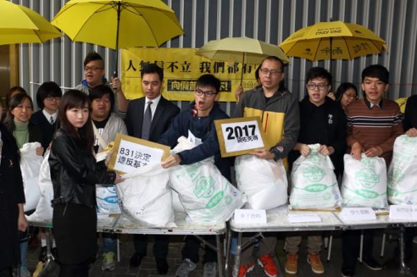 Gruppen Scholarisms talesman Oscar Lai (mitten) och ledare för sju andra demokratigrupper presenterar petitionsbrev från Hongkongborna till regeringen utanför det Lagstiftande rådet i Hongkong den 4 mars 2015. (Foto: Kiri Choi/Epoch Times)