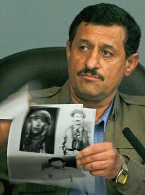 Målsägaren Mussa Abdullah Mussa visar ett dokument som innehåller bilder på människor som han säger dödades under de kemiska attackerna mot kurder under Anfal-kampanjen. Iraks förre diktator Saddam Hussein och Ali Hasan Majid, "kemiske Ali", står nu åtalade för att ha lett den. (Foto: AFP/POOL/DANIEL BEREHULAK)