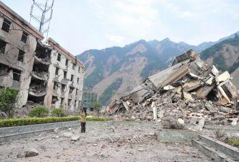 En kvinna dokumenterar resterna av en demolerad skola i den förstörda staden Yingxiu i den jordbävningsdrabbade Sichuanprovinsen. (Foto: Frederic J. Brown/AFP/Getty Images)