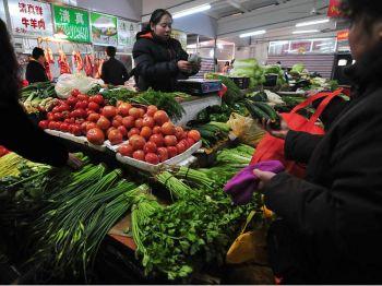 En grönsaksförsäljare räknar pengar på en marknad i Peking. (Foto: Frederic J. Brown/AFP/Getty Images)
