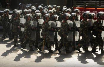Kinesiska paramilitära styrkor marscherar på en gata i Urumqi i Xinjiangregionen, 9 juli. (Foto: Peter Parks/AFP/Getty Images)
